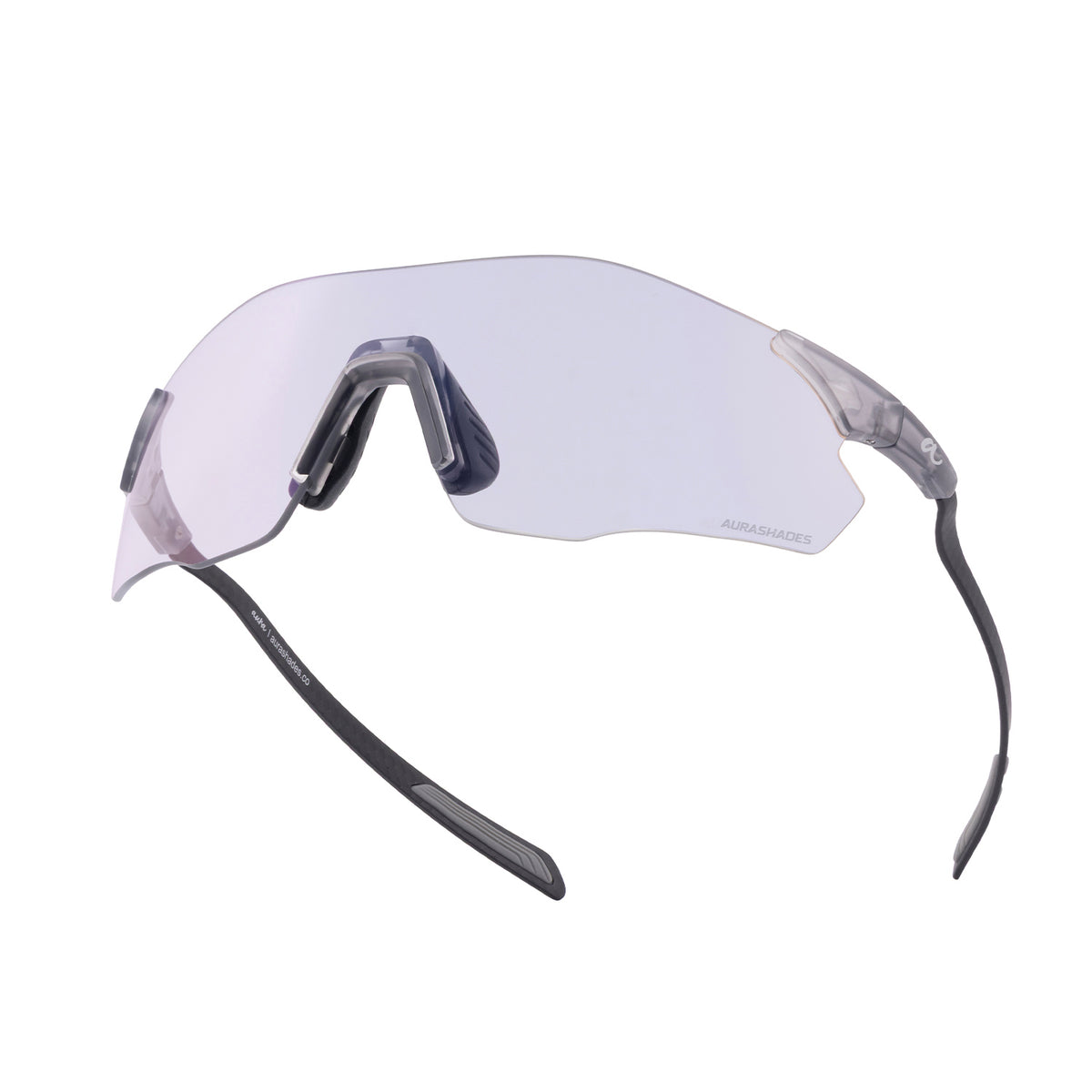 A pair of shield-style sunglasses with a clear, lightly tinted lens, dark gray nose pads, and black temples on a plain white background.