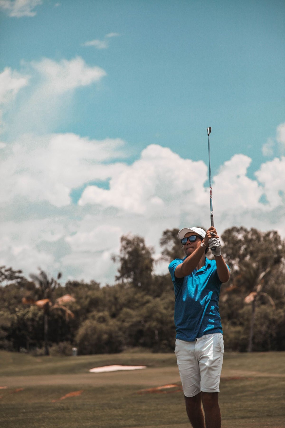 man playing golf with sunglasses