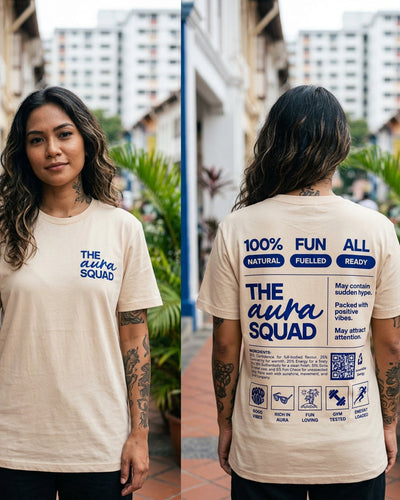 Person wearing a beige t-shirt with 'The Alpha Squad' text and graphics on both front and back, outdoors.