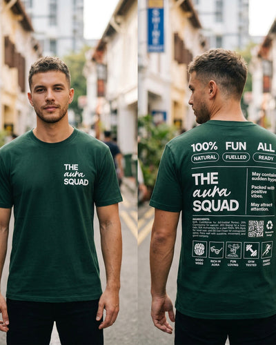 Two men wearing green t-shirts with text, one facing forward and one facing backward, in an urban setting.