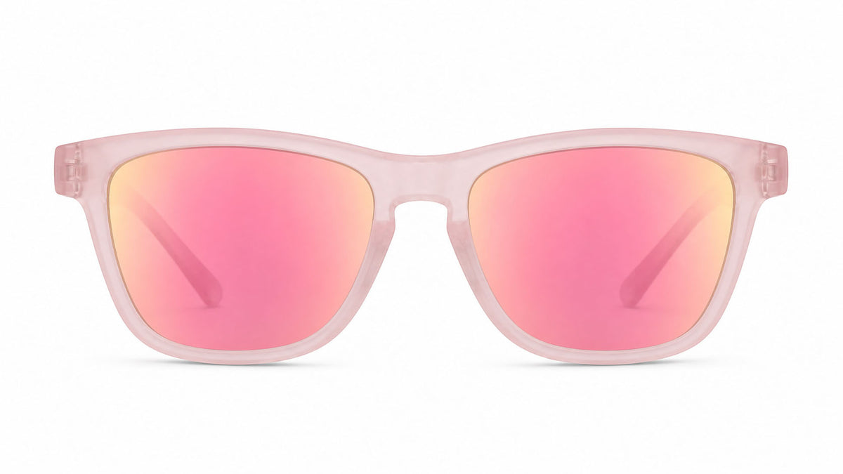 A pair of square-frame sunglasses with a translucent light pink frame and mirrored pink lenses that reflect a warm gold/orange hue, shown against a plain white background.